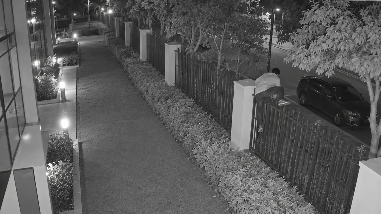 Person climbing the campus fence at 2:40 AM