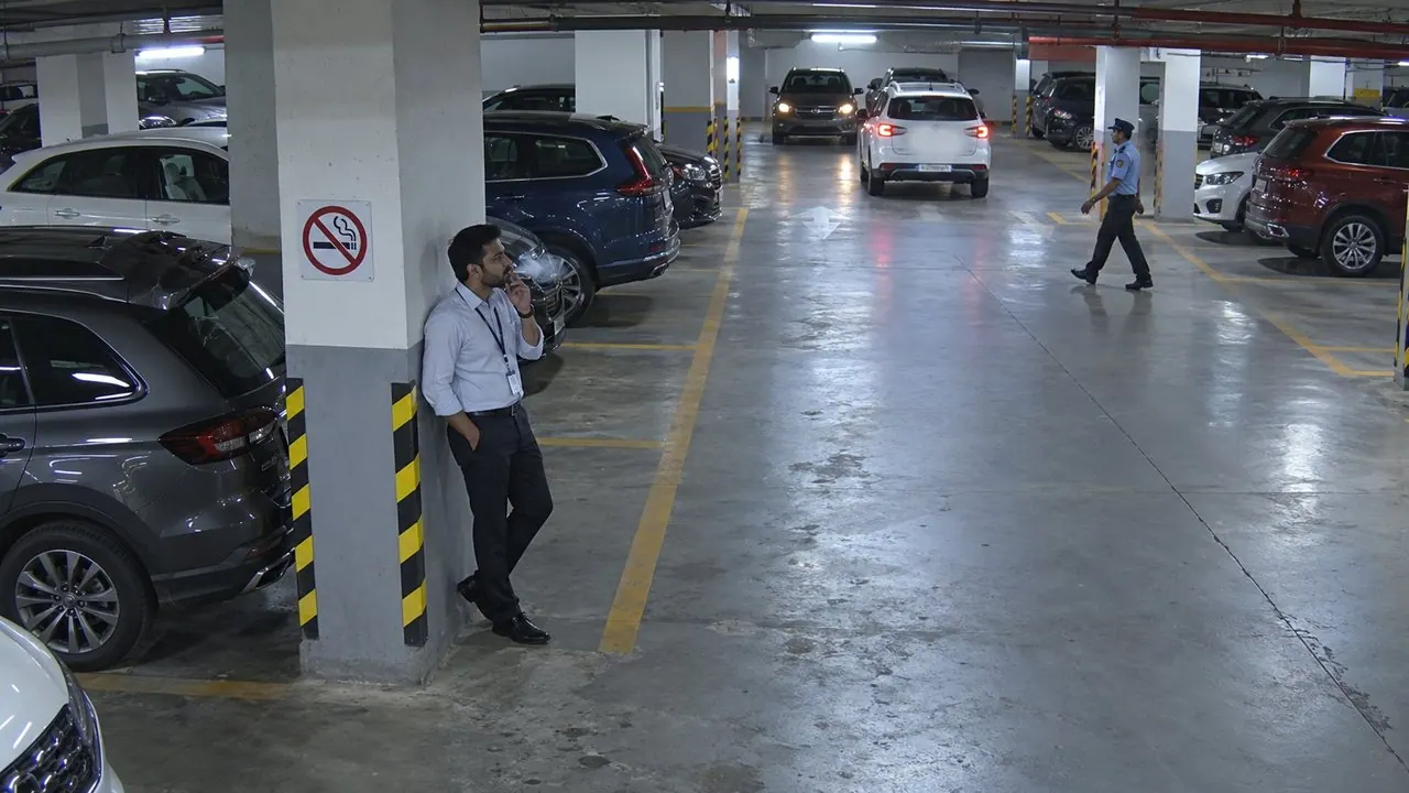 Smoking beside the no-smoking sign in the parking